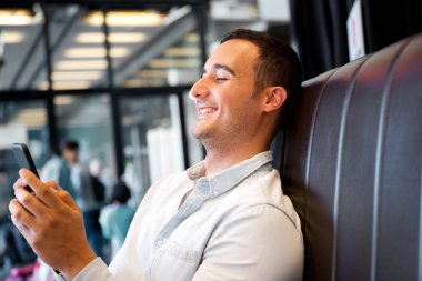 Gülümseyen ve cep telefonu arayan yaşlı bir adam portresi yan yukarıya kapatmak