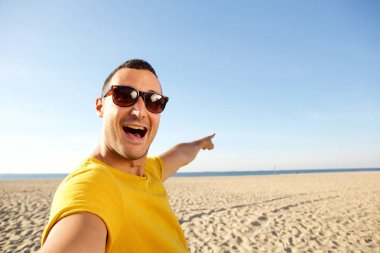 Selfie plaj ve su için işaret alarak mutlu bir adam portresi kapatın