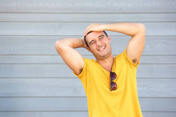 Retrato Homem Feliz Rindo Com Mãos Atrás Cabeça Contra Parede — Fotografia de Stock