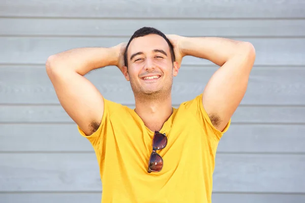 Retrato Homem Despreocupado Sorrindo Com Mãos Atrás Cabeça Contra Parede — Fotografia de Stock
