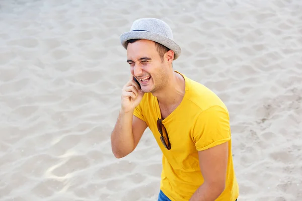 ビーチで携帯電話で話している幸せな男の側の肖像 — ストック写真