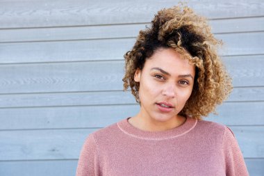 Yakın yatay dikey gri duvara güzel Afrikalı-Amerikalı kadın