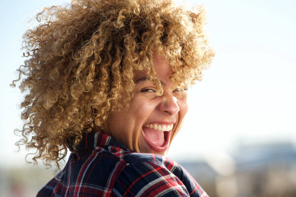 Close up horizontal portrait beautiful african american woman laughing outdoors