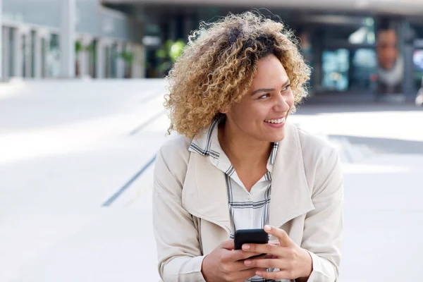 Porträtt Leende Unga Afroamerikanska Kvinna Med Mobiltelefon Utanför — Stockfoto