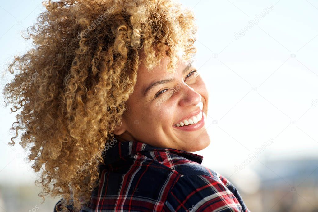 Close up portrait from behind of happy african american woman with curly hair