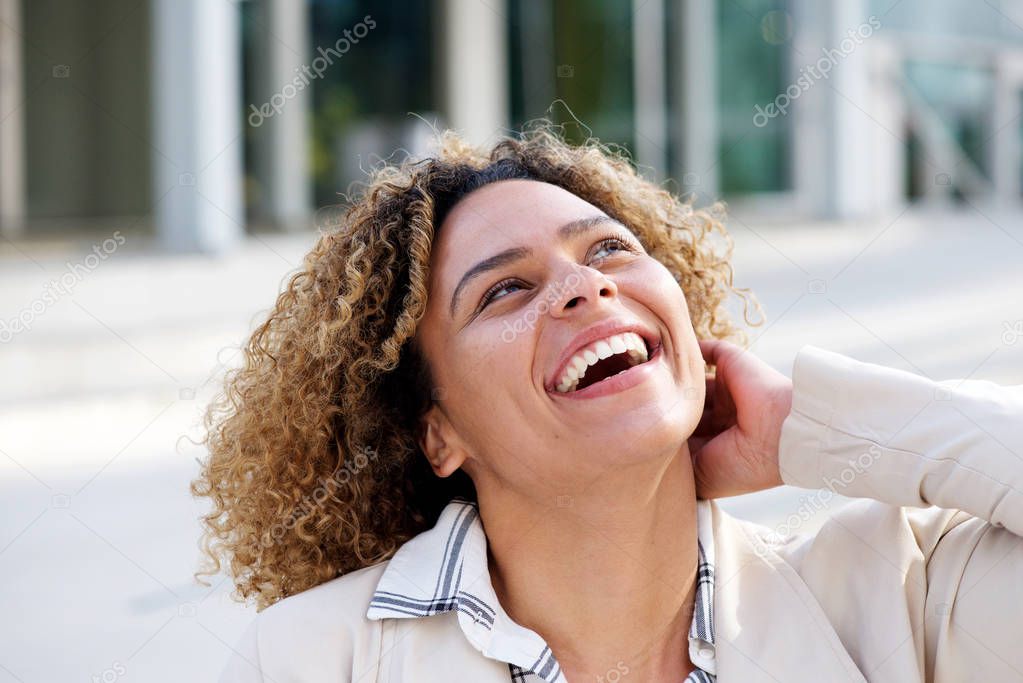 Portrait of cheerful young african american woman laughing outside
