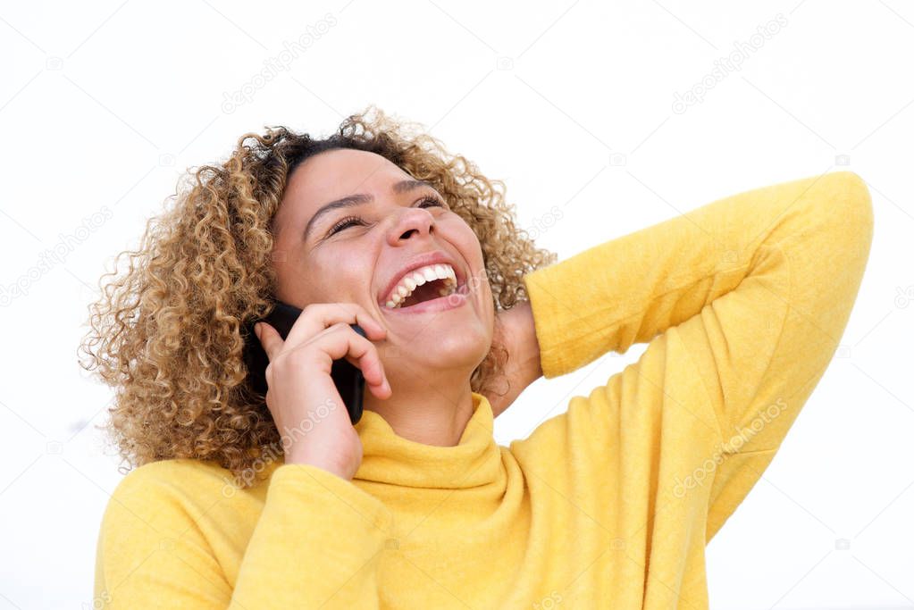 Close up portrait of beautiful african american woman talking on cellphone and laughing against isolated white background