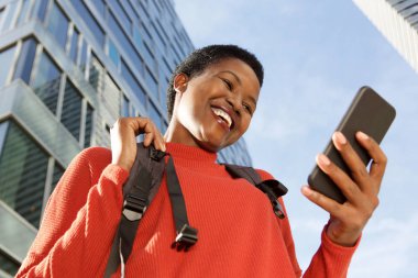 Güzel genç Afro-Amerikan kadın şehir cep telefonu bakarak portresi kapatın