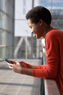 Cep telefonu arayan mutlu genç Afro-Amerikan kadın portresi yan yukarıya kapatmak 