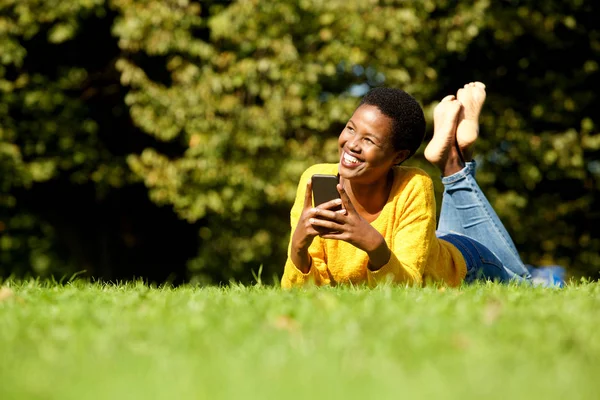 Porträtt Glad Ung Svart Kvinna Liggande Park Med Mobiltelefon — Stockfoto