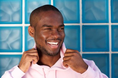 Duvarın ardında gülen yakışıklı genç Afro-Amerikan adam portresi kapatın