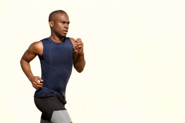 Uygun genç siyah adam beyaz duvar tarafından çalışan yan portresi