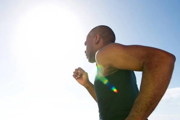在阳光明媚的日子里跑步的健康的黑人青年的一面肖像 — 图库照片