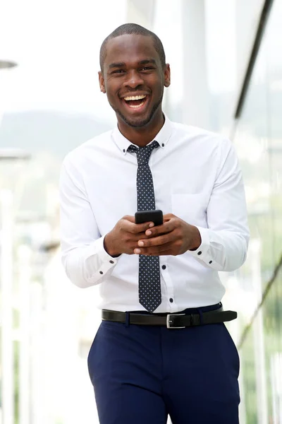 市内の携帯電話と笑ってアフリカ系アメリカ人のビジネスマンの肖像画 — ストック写真