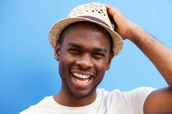 青い背景に笑顔の帽子とクールな若い黒人の男の肖像画間近します — ストック写真