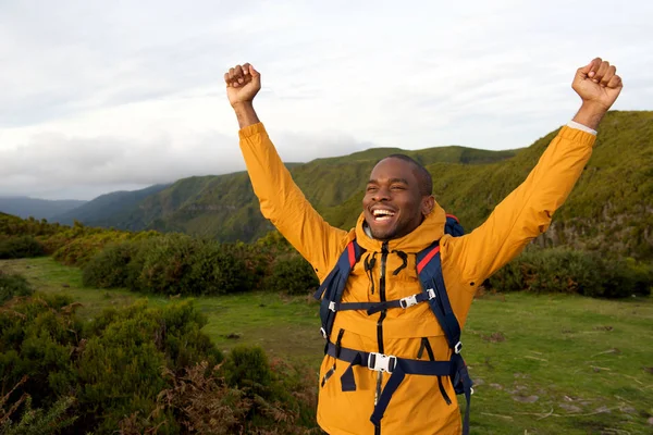 腕を上げると屋外で立って幸せのアフリカ系アメリカ人バックパッカーの肖像画 — ストック写真