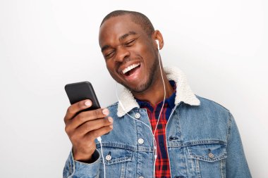 Mutlu genç Afro-Amerikan adam akıllı telefon ve kulaklık ile müzik dinlemek portresi kapatın