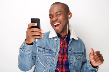 Mutlu genç siyah adam akıllı telefon ve kulaklık ile müzik dinlemek portresi kapatın 