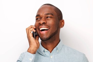 Yakın yukarı izole beyaz arka plan karşı cep telefonu ile konuşan gülümseyen genç siyah adam portre
