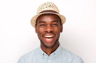 Beyaz arka plana karşı şapka ile gülüyor yakışıklı genç siyah adam portre yakın