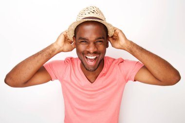 Beyaz duvara karşı şapka ile gülüyor neşeli genç siyah adam portresi