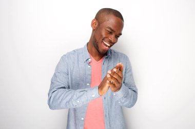 Beyaz duvar tarafından el alkışlayan mutlu genç siyah adam portresi