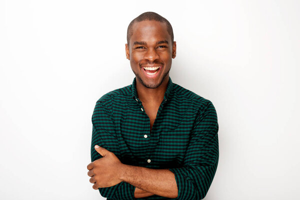 Portrait of happy young black guy smiling with arms crossed against isolated white background