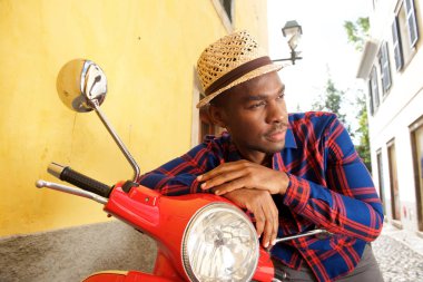 Afro-Amerikan yakışıklı açık havada motorla eğilerek portresi