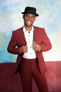 Duvar ile şapka ve Vintage takım elbise ile gülümseyen serin genç Afrikalı Amerikan erkek moda modeli portre