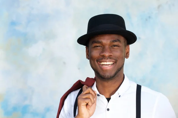 壁が微笑むサスペンダーと帽子を持つハンサムな若いアフリカ系アメリカ人男性のポートレートをクローズアップ — ストック写真