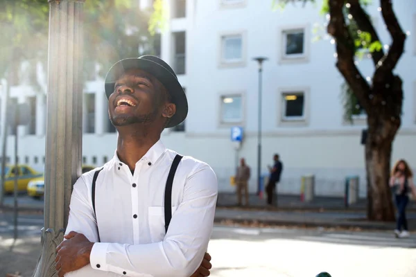 时尚的年轻非洲裔美国人的肖像与帽子笑在城市 — 图库照片