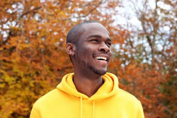 背景に秋の葉に対して微笑んでハンサムな若いアフリカ系アメリカ人男性のポートレートをクローズアップ — ストック写真