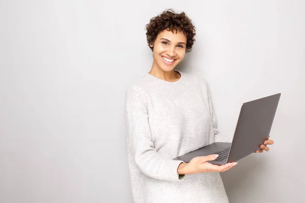 Beyaz Arka Plan Tarafından Dizüstü Bilgisayar Tutan Gülümseyen Genç Kadın — Stok fotoğraf