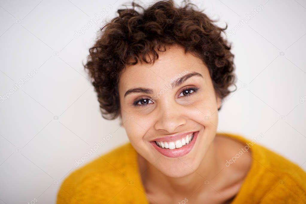 Close up portrait of smiling young mixed race woman smiling against white background