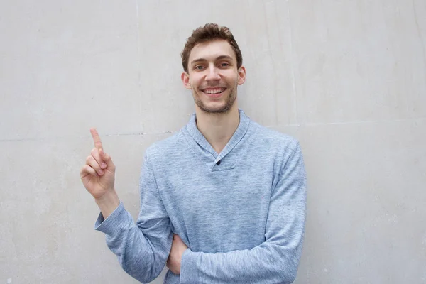 Портрет Молодого Чоловіка Який Посміхається Вказує Пальцем Вгору Порожню Стіну — стокове фото