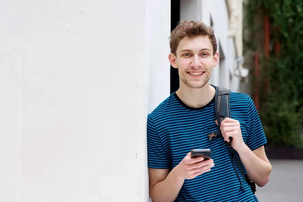 Porträt Eines Lächelnden Jungen Mannes Mit Handy Und Rucksack Wand — Stockfoto