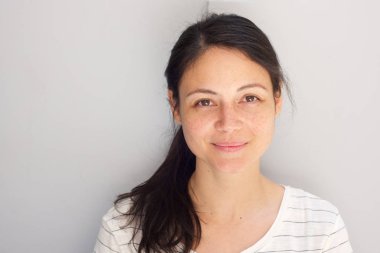 Gri arka plana karşı dikkuyruk ile güzel genç Asyalı kadının yatay portre yakın yukarı