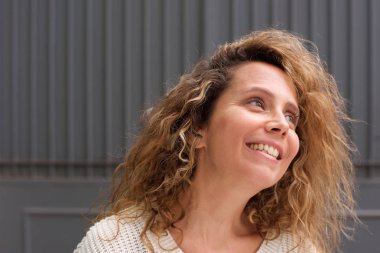 Mutlu orta yaş kadın gülümseyen ve uzak görünümlü portre yakın