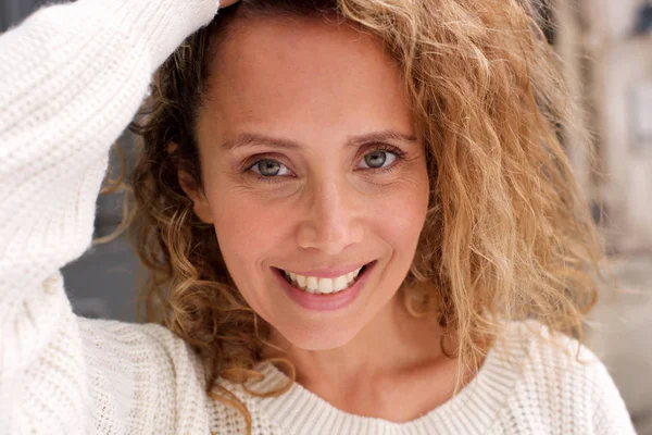 Kıvırcık saçlı el ile gülümseyen mutlu orta yaş kadının portre yakın