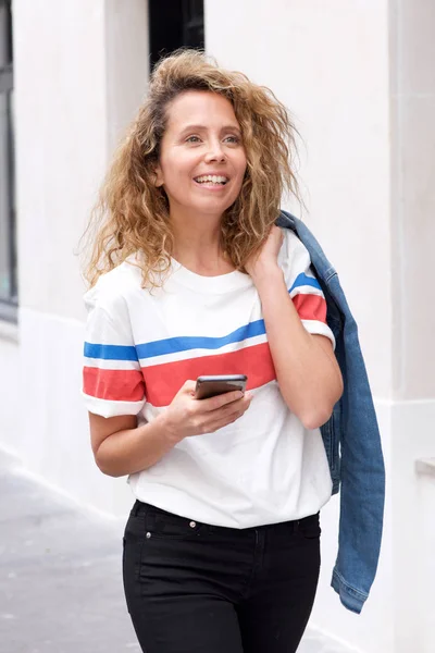 Retrato Mujer Mediana Edad Sonriente Caminando Con Teléfono Celular —  Fotos de Stock