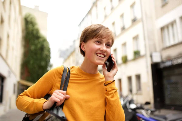 街を歩いて携帯電話で話す幸せな若いブロンドの女性の肖像画 — ストック写真