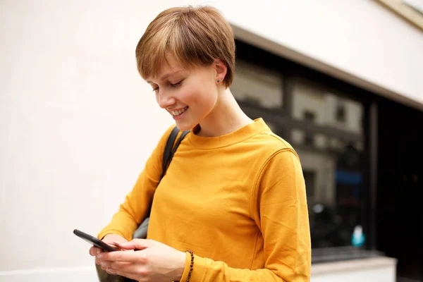 携帯電話を見て短い髪の若い女性の肖像画 — ストック写真