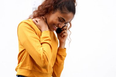 Beyaz arka plan tarafından cep telefonu ile konuşan güzel genç hintli kadının yakın portresi 