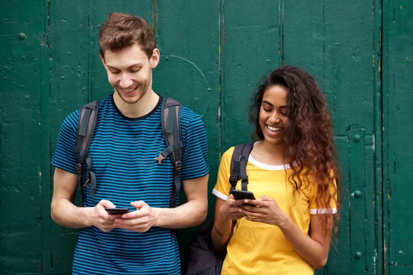 男女学生看着手机与快乐的表情的肖像 — 图库照片