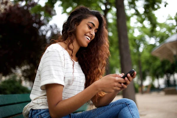 Side Porträtt Ung Indisk Kvinna Sitter Parken Och Tittar Mobiltelefon — Stockfoto