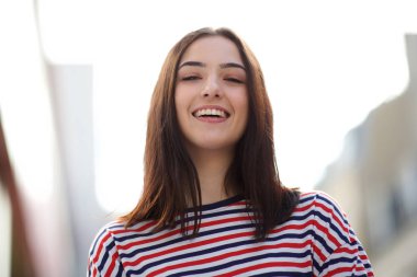 Çizgili gömlek ile gülümseyen genç kadının ön portre yakın