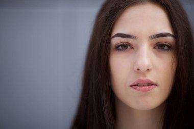 Yüzünde ciddi ifade ile güzel genç kadının yakın ön portre