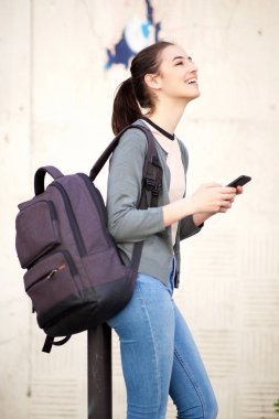 Cep telefonu tutan çanta ile mutlu genç kadın portresi 