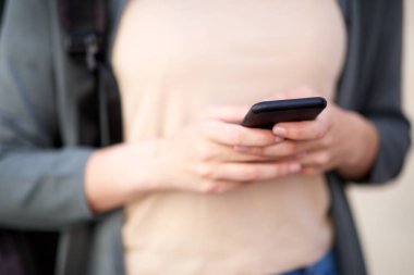 Cep telefonu tutan kadın ellerin yakın portresi