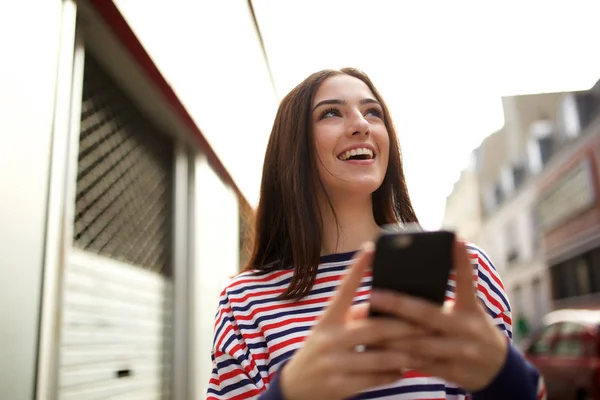 市内の携帯電話を持つ幸せな若い女性の肖像画 — ストック写真